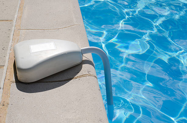 Swimming pool alarm positioned on the side of a home swimming pool